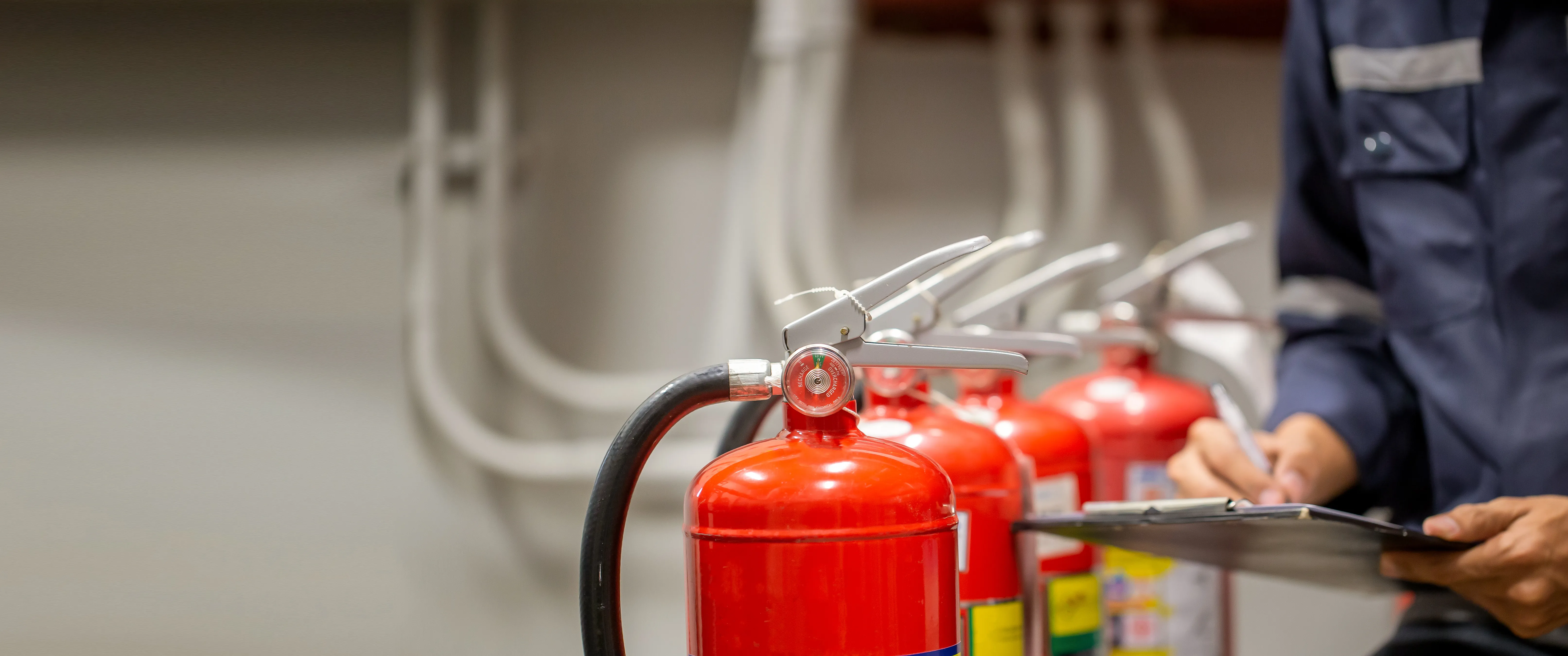 a fire extinguisher writing on a clipboard next to fire exting