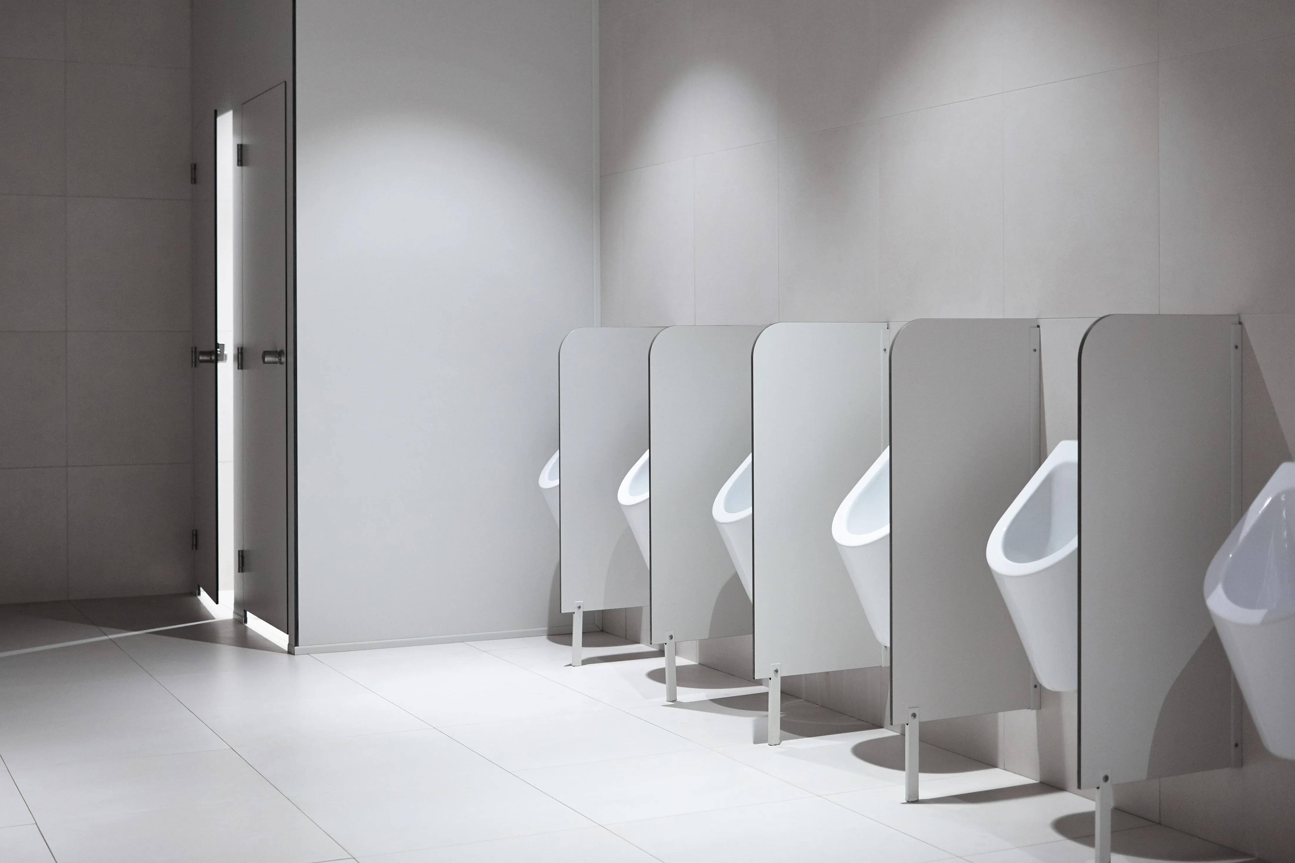 a row of white urinals in a bathroom